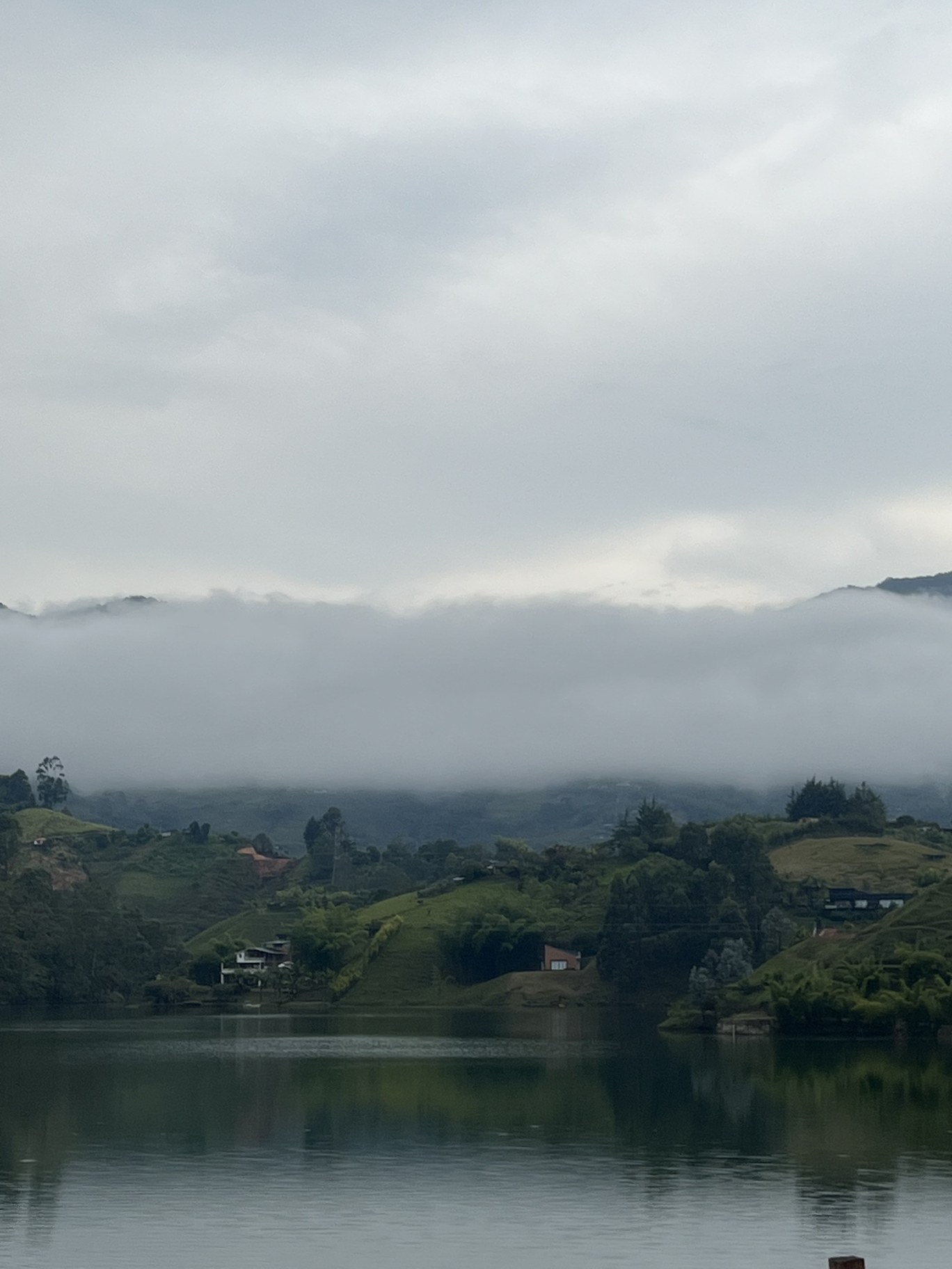Mist over the lake and green hills of Guatapé, Colombia